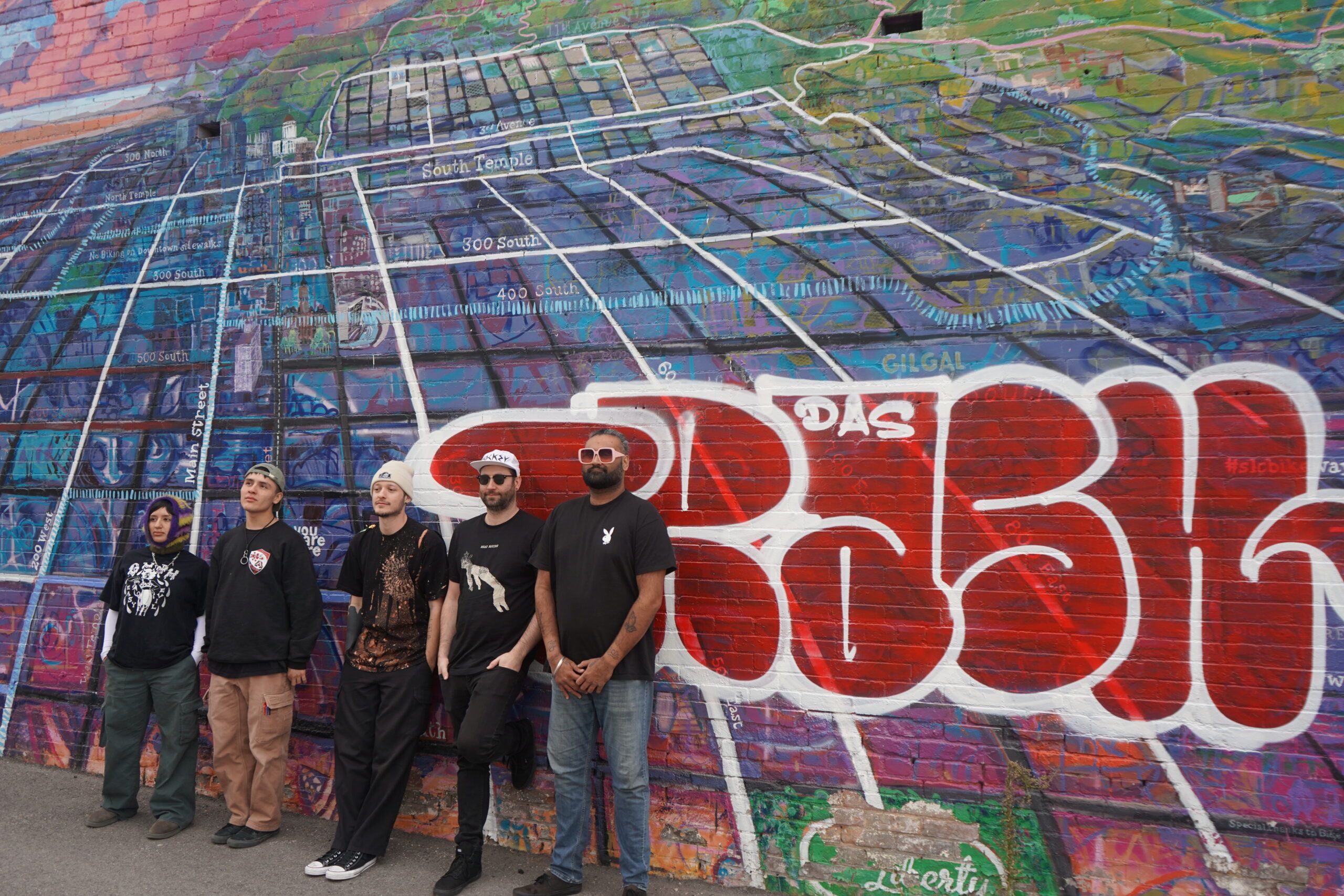 Drowning Lessons band photo, lined up against graffiti mural wall